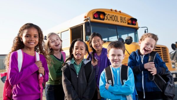 Young special ed children near schoolbus
